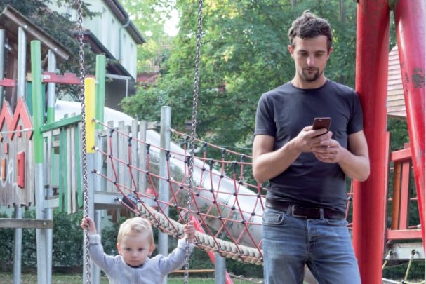 Vater mit Kind auf dem Spielplatz